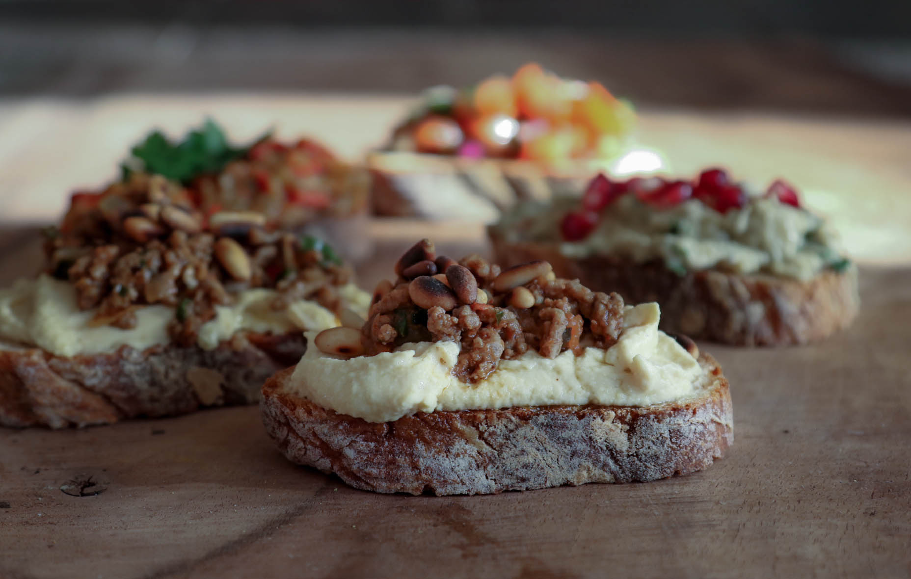 Orientalischer Fingerfood: Hackfleisch mit Pinienkernen auf Humus ...